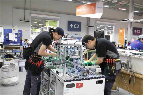 現從事有關機械自動化工程的Tony(左)指出,為自動化系統編寫程式後,需要利用模擬器反覆測試系統,確保運作順暢,才會把程式放在機器測試及應用。他的日常工作除編寫系統電腦程式外,亦要為自動系統設置硬件,包括安裝機件及鋪置電線等。圖為2019年Tony參與「世界技能大賽」時所攝。 現從事有關機械自動化工程的Tony(左)指出,為自動化系統編寫程式後,需要利用模擬器反覆測試系統,確保運作順暢,才會把程式放在機器測試及應用。他的日常工作除編寫系統電腦程式外,亦要為自動系統設置硬件,包括安裝機件及鋪置電線等。圖為2019年Tony參與「世界技能大賽」時所攝。